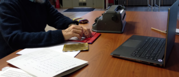 Photo de la sensibilisation avec l'ordinateur pour la visio conférence ainsi que du matériel dont une machine à écrire, ainsi qu'un outil d'écriture en braille