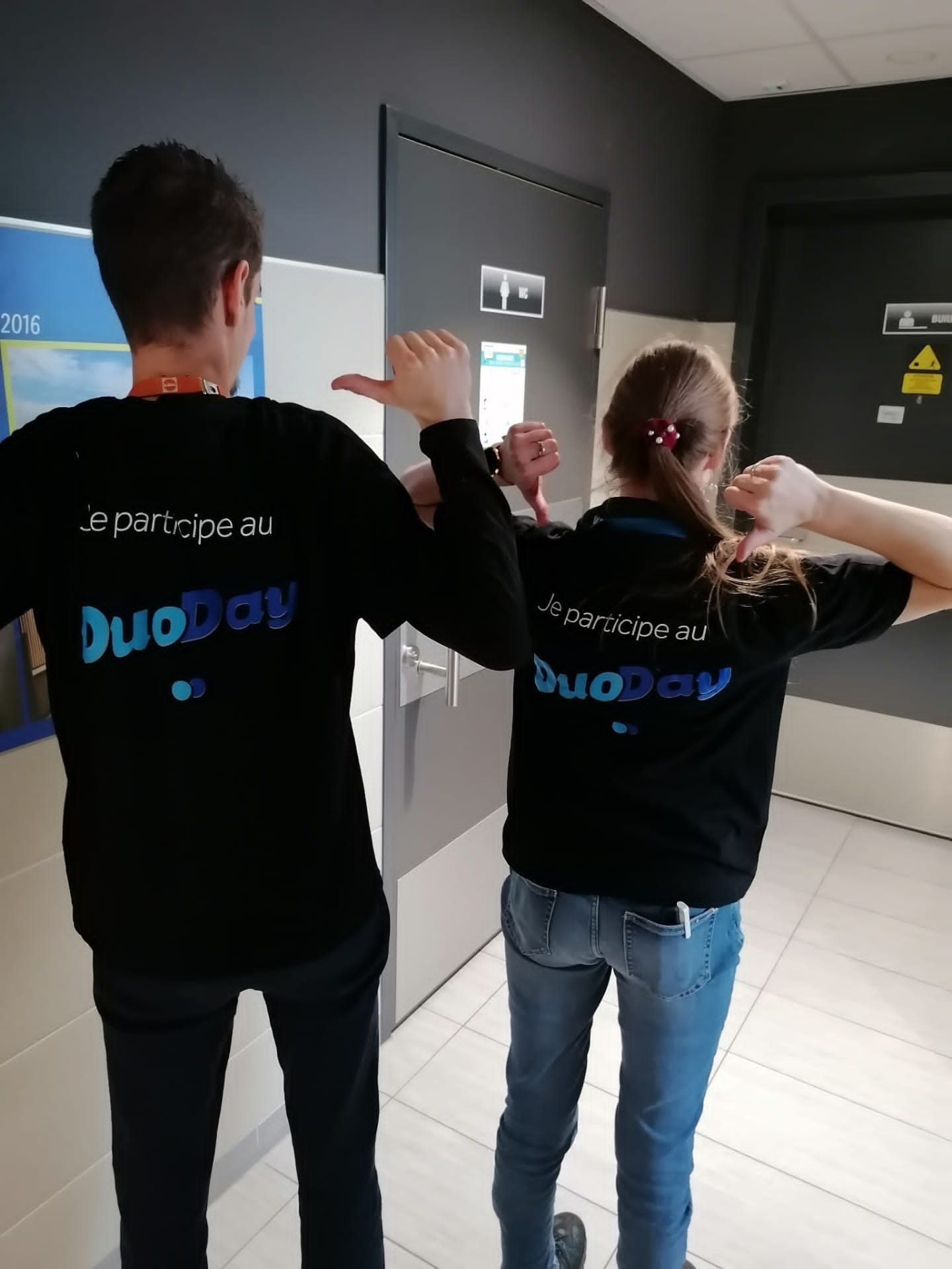 photo de Sophie BAYER et son référent DuoDay, de dos, avec le polo de l'événement DuoDay