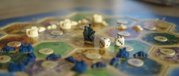 plateau de jeu avec deux dés et des pions posés sur des cases