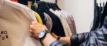 Une personne choisissant un tee shirt dans un rayon de vêtements