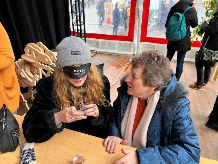 Une participante aidée de Solange BOEGLIN pour la deuxième étape : l'odorat.