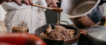 Personne versant une marinade sur une pièce de bœuf